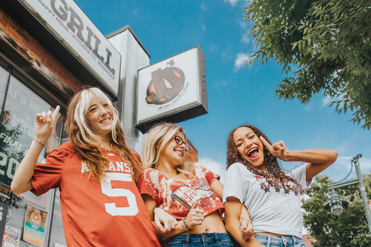 three girls in Razorback shirts in front of JJ's Grill Restaurant