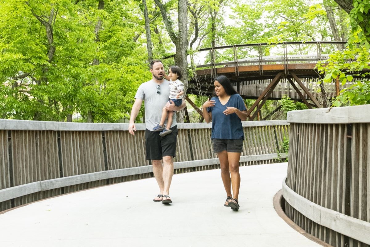 Family walking on trail through the trees