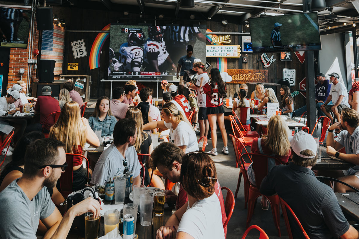 people eating and watching sports on TVs at JJ's on Dickson