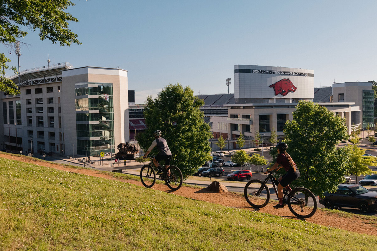 people riding bicycles in front of Razorback Stadium in Fayetteville, Arkansas