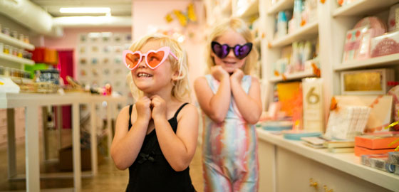 Two child wearing colorful heart-shaped sunglasses